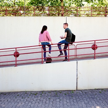 Two young people sitting on railings